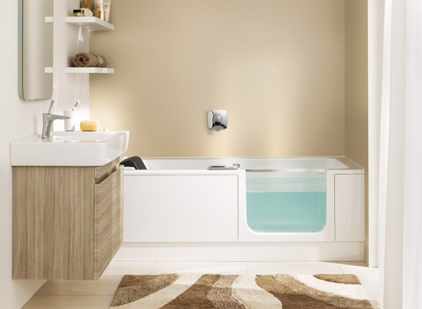Baignoire à porte Artweger Twinline 2 avec paroi vitrée et ouverture latérale, installée dans une salle de bains moderne beige et bois clair