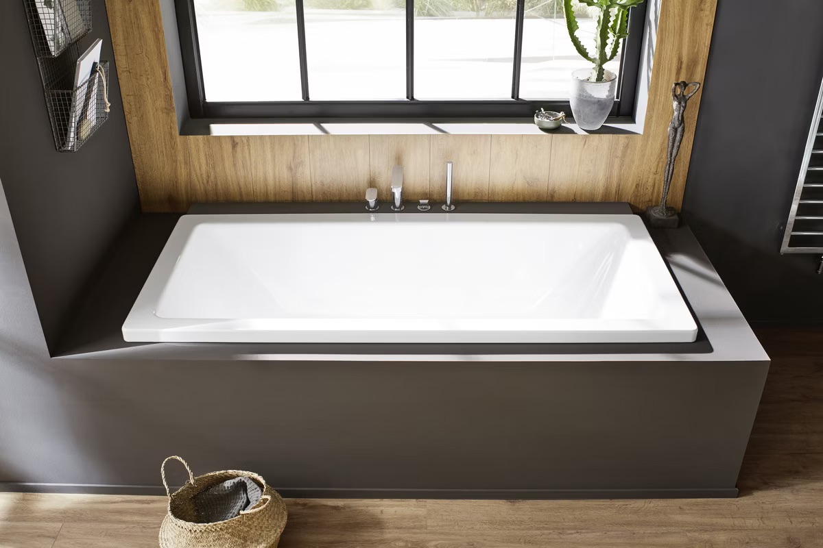 Baignoire encastrée Kaldewei Conoduo installée dans une salle de bains contemporaine avec habillage mural clair