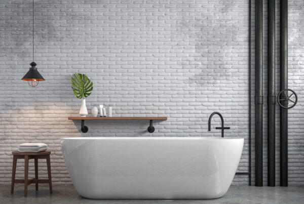 Salle de bains style industriel avec mur en briques blanches, tuyaux noirs apparents, baignoire contemporaine et robinetterie noire mate