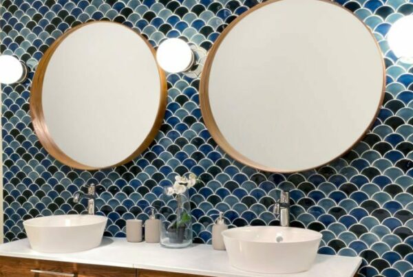 Mur en zellige bleu à motifs écailles dans une salle de bains avec double vasque et meuble en bois