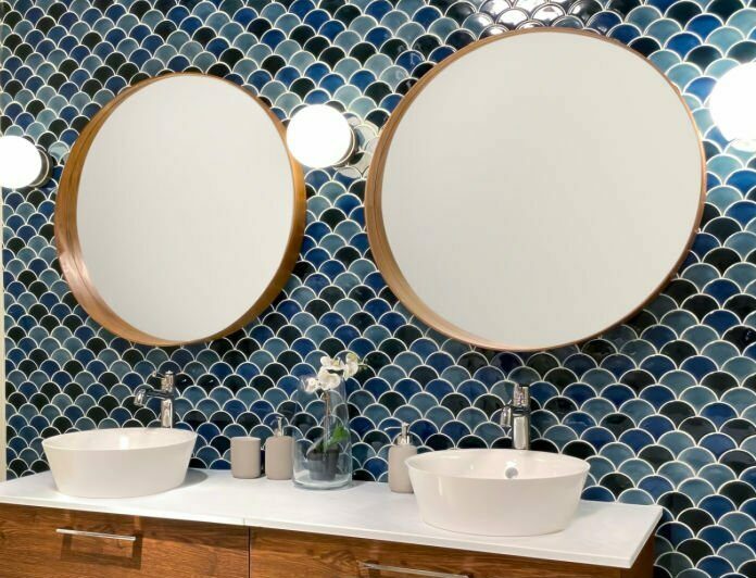 Mur en zellige bleu à motifs écailles dans une salle de bains avec double vasque et meuble en bois