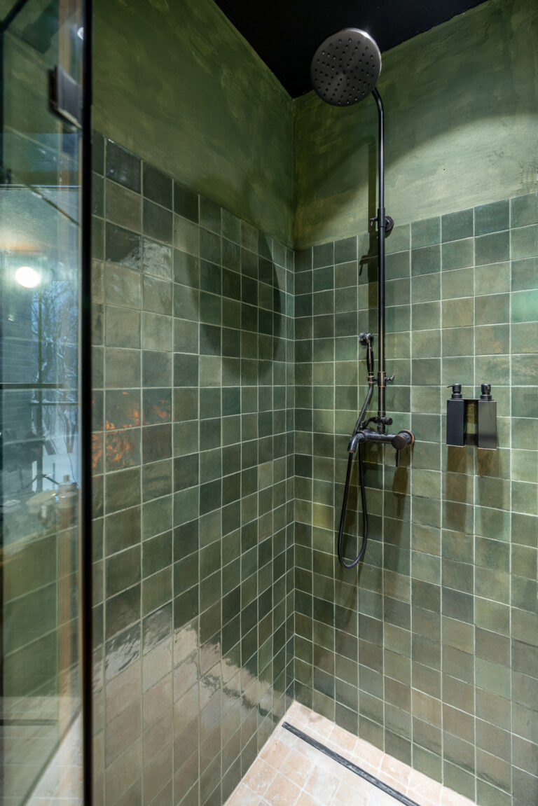 Douche moderne avec carrelage mural en zellige vert et pommeau de douche noir mat