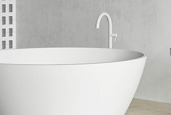 Baignoire îlot blanc mat Hidrobox dans une salle de bains épurée en tons gris, avec colonne assortie