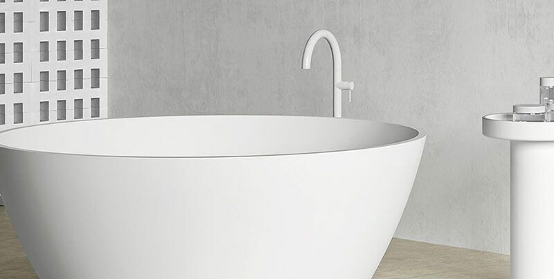 Baignoire îlot blanc mat Hidrobox dans une salle de bains épurée en tons gris, avec colonne assortie