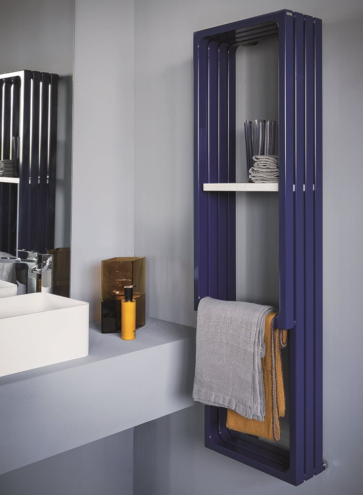 Sèche-serviettes design bleu, modèle Tubes avec tablette intégrée, installé dans une salle de bains contemporaine aux murs gris