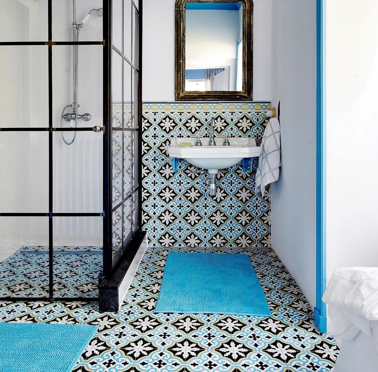 Salle de bains Carocim avec sol et murs en carreaux de ciment motif provençal bleu, noir et blanc