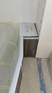 Salle de bains en travaux avec tablier de baignoire en cours de préparation.