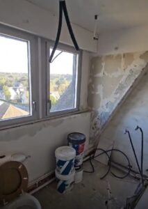 Début de chantier salle de bains, gros œuvre avec murs mis à nu et préparation technique.
