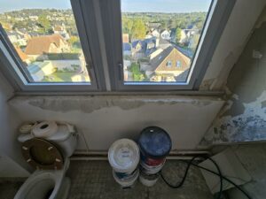 Salle de bains en rénovation, gros œuvre avec anciens WC et murs mis à nu avant réaménagement.