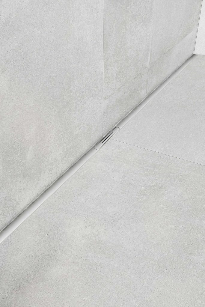 Caniveau de douche linéaire intégré le long d’un mur dans une douche carrelée